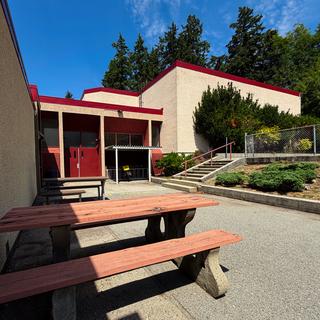 Picnic tables and entrance to cafe and gymnasium at tiwšɛmawtxʷ